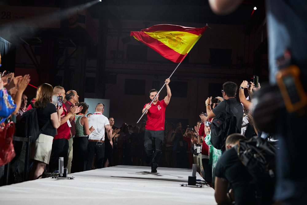 Best of Belron: técnico representando a España en la competición sosteniendo la bandera