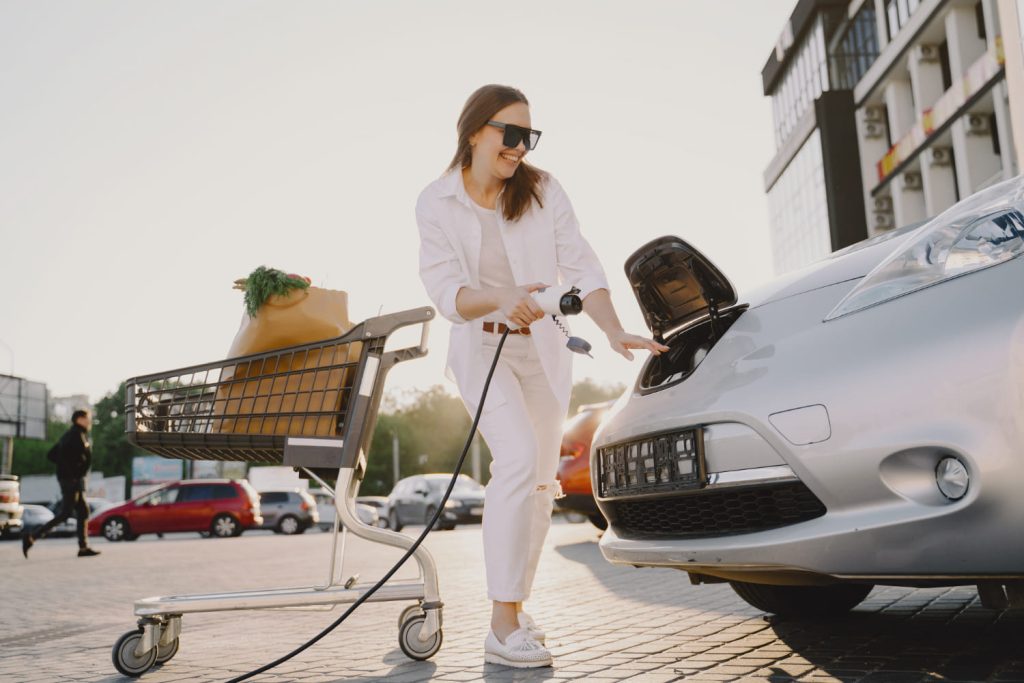 Mujer con recarga de un coche eléctrico