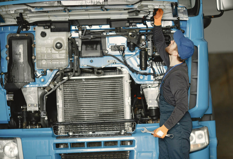 hombre arreglando la bateria del camión