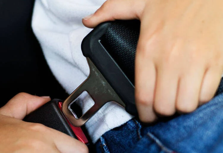 Seguridad activa y pasiva del vehiculo: persona abrochándose el cinturón de seguridad