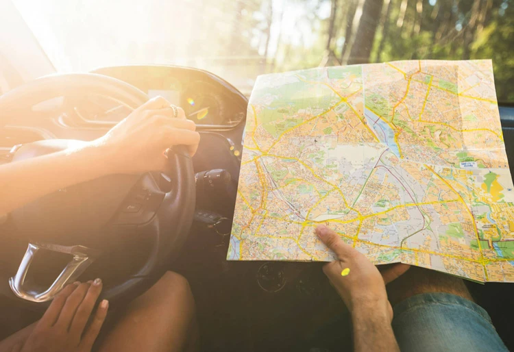 Ruta en coche por Merindades en Burgos: persona conduciendo con un mapa delante