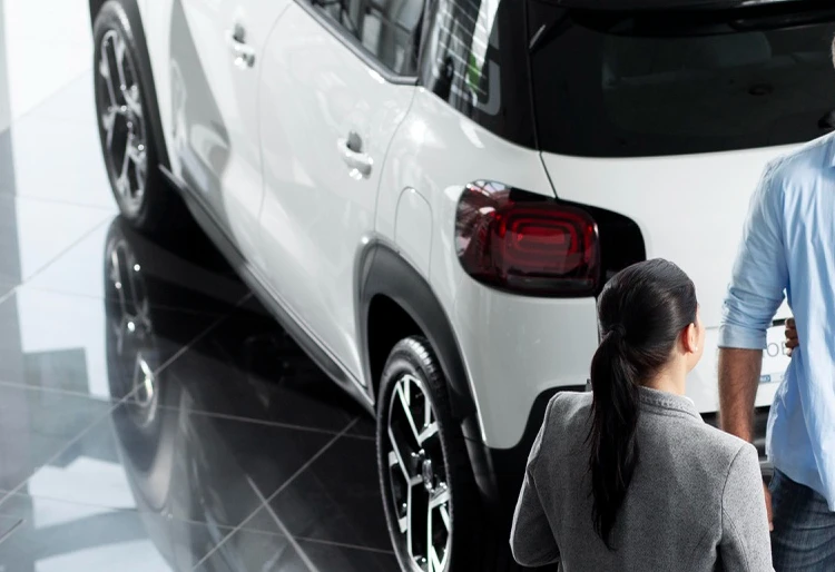 Coche kilometro 0 - dos personas al frente y un coche blanco detras