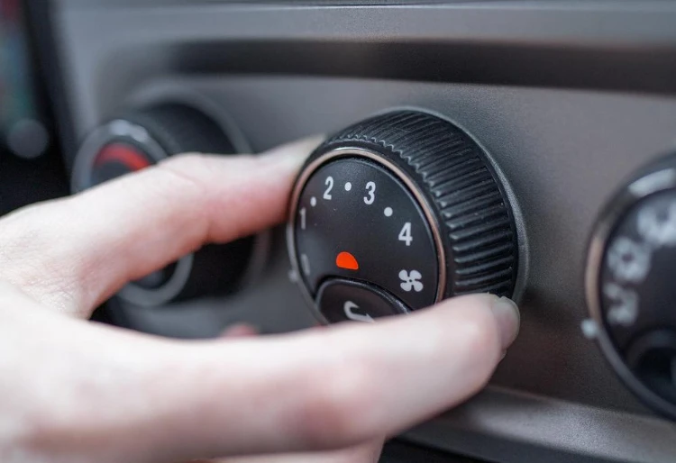 Aire acondicionado - Carglass:mano ajustando el aire acondicionado de un coche