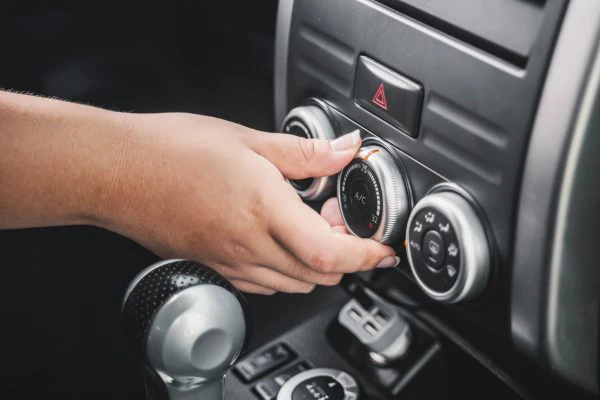 Una mano regulando el calefactor del coche 