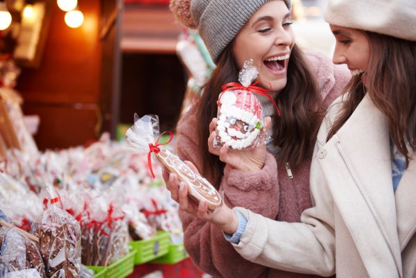 dos mujeres sonriendo en un mercado navideño