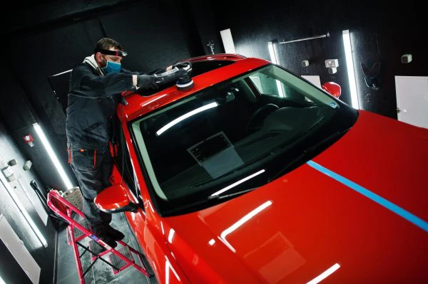 mecanico pintando un coche rojo