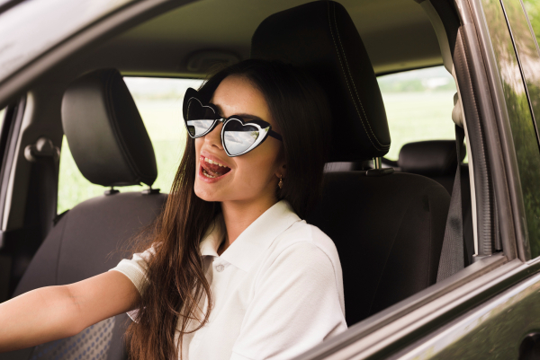 mujer con gafas de sol dentro de un coche 
