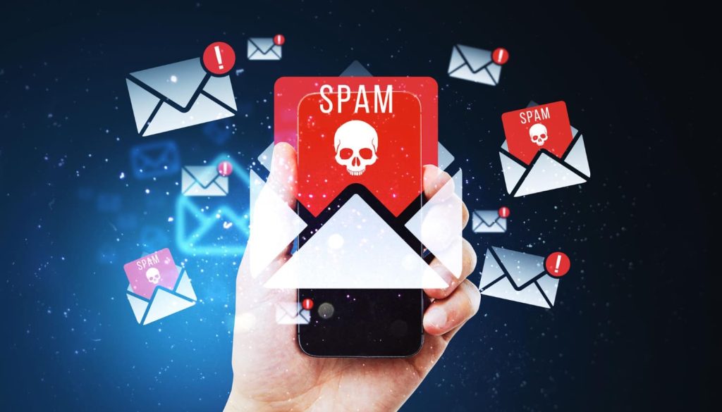 Mano sosteniendo un teléfono con íconos de correos marcados como spam y advertencias de seguridad, enfatizando cómo evitar estafas en carretera - Carglass.
