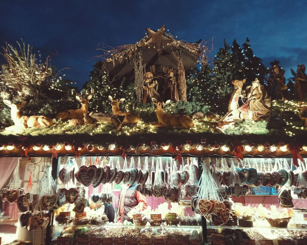 
Puesto decorado con un nacimiento, renos iluminados y galletas de jengibre en un mercado navideño de Madrid - Carglass.