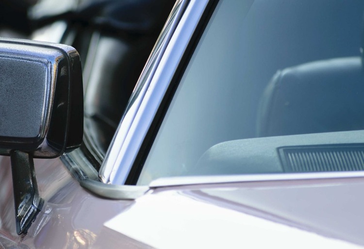 Primer plano del faro delantero de un automóvil, con el parabrisas donde podría estar el número VIN - Carglass.