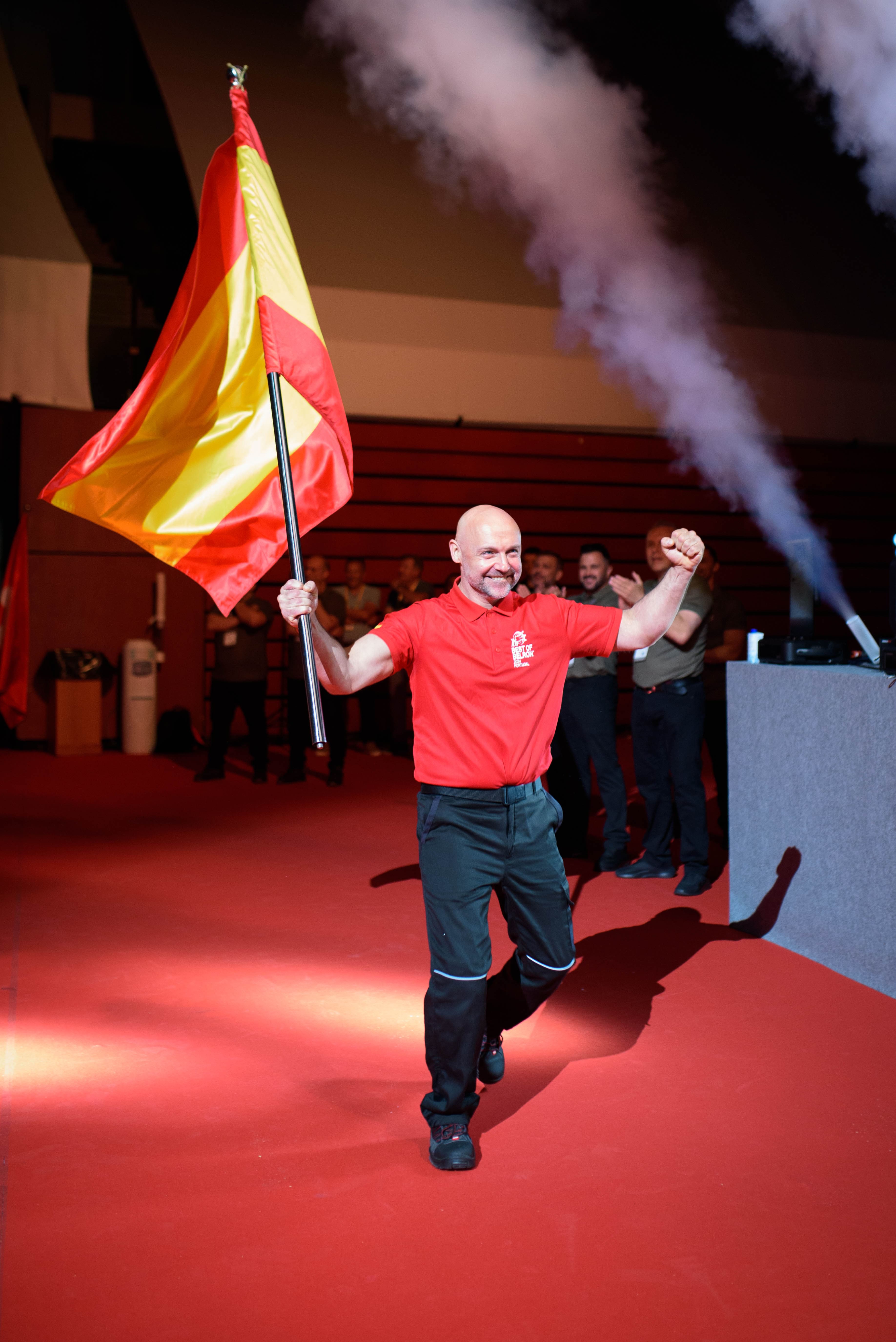 Best of Belron: técnico representando a España en la competición sosteniendo la bandera